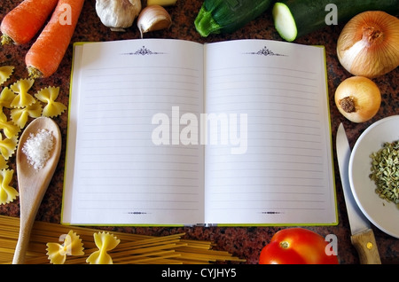 Vista dall'alto di un vuoto ricettario circondato degli ingredienti di alimenti e di utensili da cucina Foto Stock