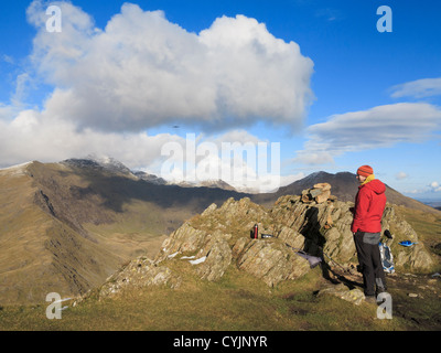 Walker avente una rottura sul Yr Aran vertice con vista di Mount Snowdon cresta sud nel Parco Nazionale di Snowdonia North Wales UK Gran Bretagna Foto Stock