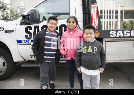 I bambini di attendere per il papà per ottenere gas in linea lunga dopo l uragano Sandy colpire l'area di New York City. Brooklyn, New York. Foto Stock