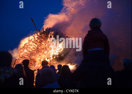 La gente sta guardando un enorme falò, una tradizione con la pasqua in Europa nord-occidentale. Foto Stock