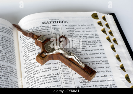 Una Bibbia aperta con una croce giacente su di una pagina Foto Stock