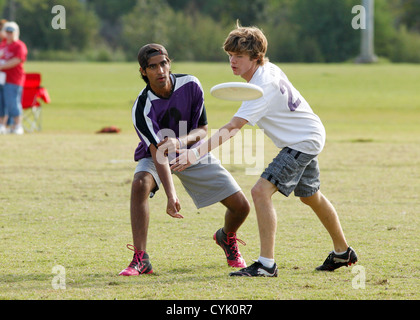 Ragazzo adolescente custodisce il suo avversario durante un ultimate frisbee gioco presso una scuola superiore nel torneo di Austin in Texas Foto Stock