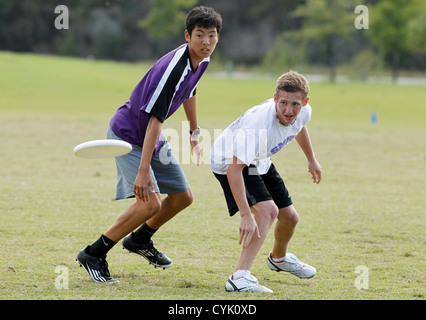 Ragazzo adolescente custodisce il suo avversario durante un ultimate frisbee gioco presso una scuola superiore nel torneo di Austin in Texas Foto Stock