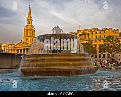 Fontana in Trafalgar Square con St Martins nei campi in background Foto Stock
