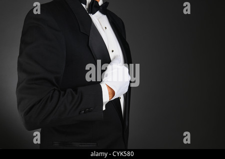 Closeup profilo di un uomo che indossa uno smoking e guanti bianchi tenendo  la sua giacca Foto stock - Alamy