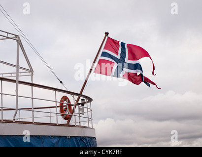 Stato norvegese e bandiera navale sventolare nel vento in poppa di una nave in porto di Oslo Foto Stock