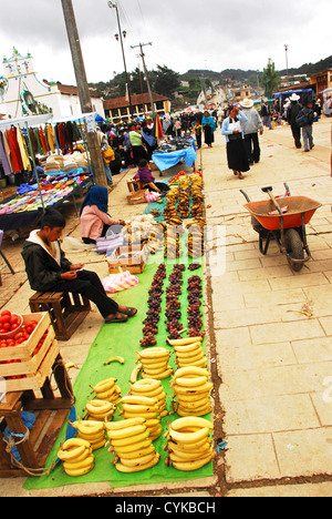 Messico, San Juan de Chamula, alimenti disposti in una fila e visualizzato per la vendita al mercato dalla ruota barrow Foto Stock