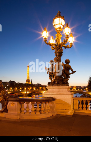 Lampione ornati da Pont Alexandre III con Senna e dalla Torre Eiffel al di là, Parigi Francia Foto Stock