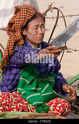 Myanmar Birmania. Donna di pa-O gruppo etnico al mercato locale, Lago Inle, Stato Shan, tramandando cambiare a un cliente. Foto Stock