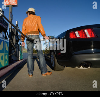 L'uomo riempimento auto con gas Foto Stock