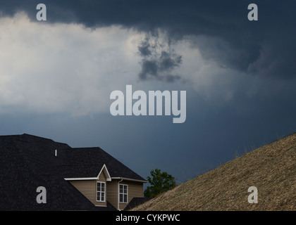 Nuvole temporalesche raccolta su house Foto Stock