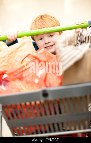 Ragazzo spingendo il carrello in negozio di alimentari Foto Stock