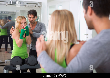 Boxer a fare pratica con il trainer in palestra Foto Stock