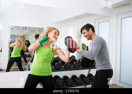 Boxer a fare pratica con il trainer in palestra Foto Stock