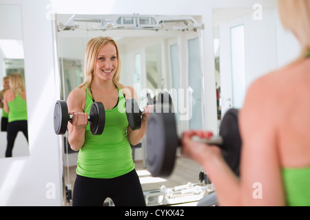 Donna sollevamento pesi nella palestra Foto Stock
