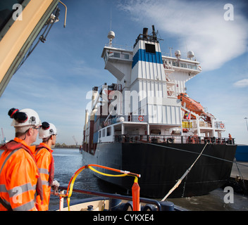 Lavoratori sul rimorchiatore affacciato sulla nave Foto Stock