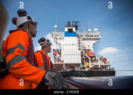 Lavoratori sul rimorchiatore tirando in corda Foto Stock