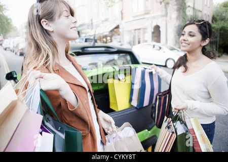 Le donne il caricamento di borse per lo shopping in auto Foto Stock