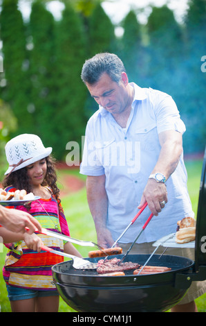 Padre e figlia la cottura alla griglia all'aperto Foto Stock