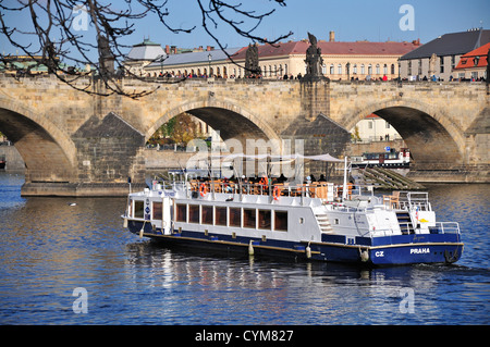 Praga, Repubblica Ceca. La barca turistica sul fiume Moldava (Moldau) - Charles Bridge Foto Stock