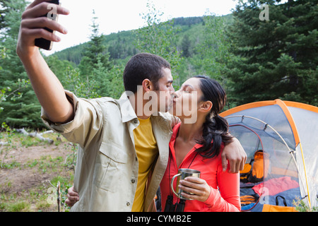 Giovane camping, baciare e tenendo Self-portrait Foto Stock