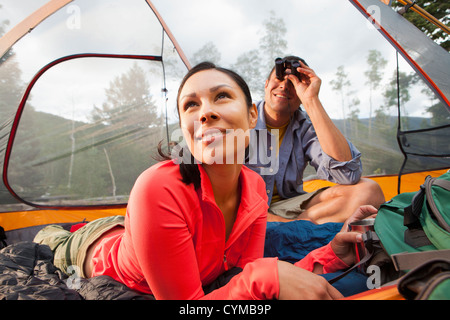 Giovane seduto in tenda insieme Foto Stock