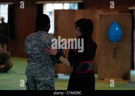 Camp Imazu, Giappone - Sgt. Selena Britton di Montgomery, Ala., sergente di alimentazione con sede e Sede Società, 1° Battaglione, quattordicesimo Reggimento di Fanteria fuori Schofield caserma, Hawaii, getta un colpo dart attraverso un palloncino durante un ninja demonstra Foto Stock