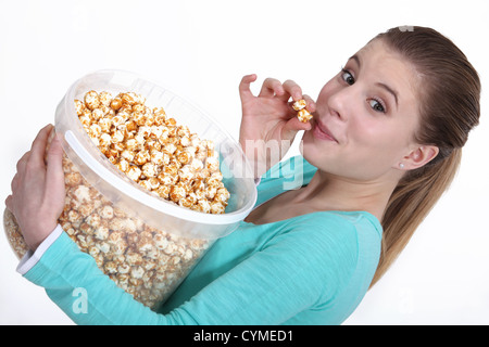 Donna mangiare popcorn Foto Stock