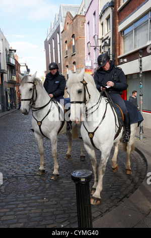 Garda siochana polizia montata a cavallo prendendo appunti di Temple Bar a Dublino Repubblica di Irlanda Foto Stock