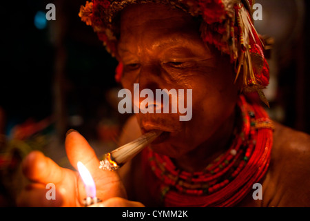 Mentawai uomini medicina, ricoperti di tatuaggi, eseguire le cerimonie per i visitatori su Kandui Isola, inclusi balli, canti e smo Foto Stock