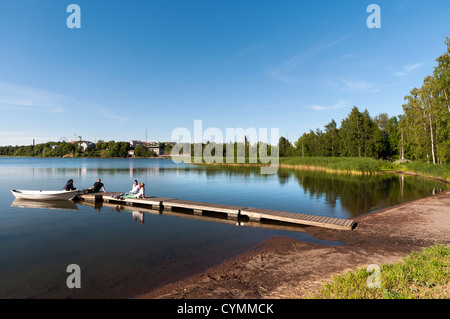 I Finlandesi rilassante godendo il sole di sera sulla baia di Töölönlahti a Helsinki in Finlandia Foto Stock