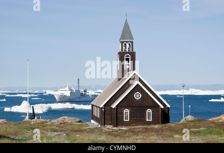Storica Chiesa di Sion ad Ilulissat, baia di Disko, SW Groenlandia con nave Akademik Ioffe in background Foto Stock