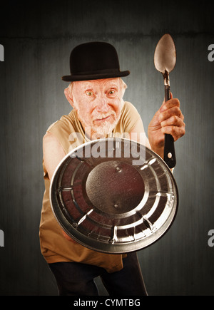 Senior nel cappello bowler difende con cucchiaio e coperchio Foto Stock