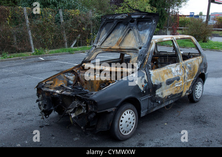 Un bruciato auto abbandonate in un fuori città retail estate a fianco del N20 autostrada del sud di Parigi. È stata una Fiat Panda? La Francia. Foto Stock