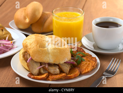 Tipica colazione peruviana consistente in padella con Chicharron (Bun con la carne fritta) e fritto di patate dolci e Massimo Mauro (sulla sinistra) Foto Stock