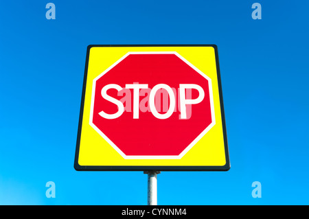 Nuova protezione del traffico di un segno di stop rosso in giallo fluorescente Foto Stock