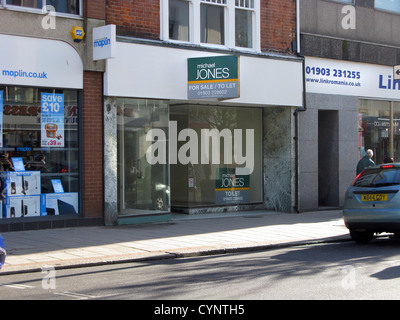 Vuoto non occupato store retail in Worthing West Sussex Regno Unito con una di lasciare in vendita la scheda Foto Stock