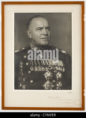 Marshal Georgy Konstantinovich Zhukov (1896 - 1974) - una foto con dedica al generale Koenig, ritratto nell'uniforme del maresciallo con numerose medaglie. Il monte con una dedica cirillica scritta a mano in inchiostro scuro 'Al generale francese Koenig, rispettosamente maresciallo Zhukov, città di Berlino 11/09/45'. In basso a destra la firma del fotografo 'G. Velo'. Incorniciato e sotto vetro, dimensioni 55 x 42 cm. Il maresciallo Zhukov era capo dello staff generale e segretario di difesa sovietico. Divenne noto per aver difeso con successo Mosca e per essere uscito vittorioso nel Foto Stock