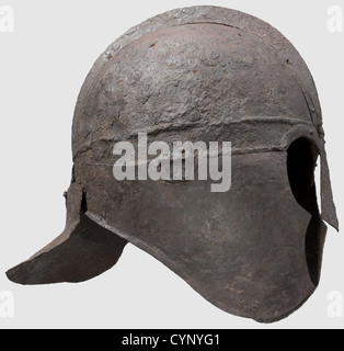 Un casco in ferro tardo romano, del IV/V secolo d.C. formato da più sezioni incernierate e rivettate in posizione, la calotta con una fascia di fronte staccata da nervature orizzontali, le due metà della calotta unite ad una cresta centrale da rivetti, le brocce di guardia del naso e ornamentali ad arco rivettate alla fascia di fronte, le guance Flangiato verso il collo e incernierato alla fascia di fronte, ciascuno forato sotto il mento, la protezione del collo con una flangia emisferica everted incernierata alla parte posteriore della fascia di fronte altezza 27.5 cm, peso 1426 grammi.provenienza: American Private Collection,, Additional-Rights-Clearences-Not Available Foto Stock