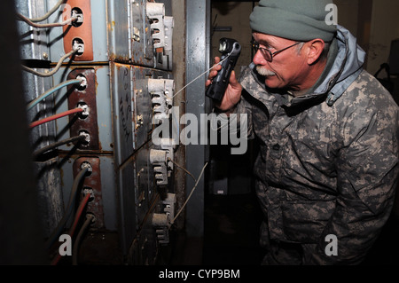 Sgt. 1. Classe Marty Newman, dell'W.Va. Esercito Nazionale Guardia 3664th dell'impresa di manutenzione, ispeziona danneggiato i pannelli elettrici nel seminterrato di un appartamento Brooklyn complesso che allagato durante l uragano di sabbia. Più di 3 metri di acqua di mare inondazioni cau Foto Stock