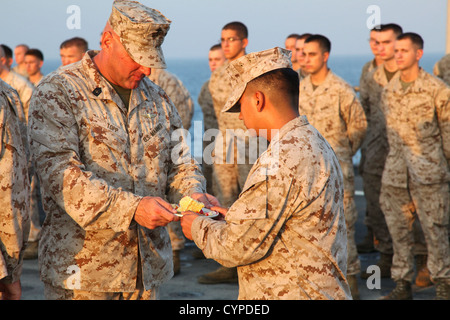 I Marines della 15th Marine Expeditionary Unit partecipano ad una preghiera durante una celebrazione del primo compleanno del corpo dei Marines a bordo della USS Rushmore. L'evento onora le tradizioni e la storia del corpo dei Marines. Foto Stock