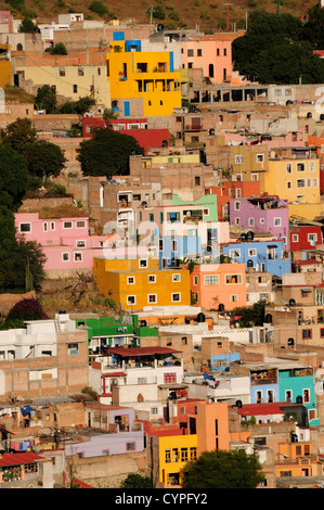 Messico, Bajio, Guanajuato, vista in elevazione di fronte dipinto luminosamente alloggiamento con tetti piana costruita sulla collina. Foto Stock