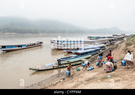 LUANG Prabang, Laos - un gruppo di donne a sbarcare da un sampan dopo aver attraversato il fiume Mekong vicino a Luang Prabang in testa al mercato di mattina nelle vicinanze. Foto Stock