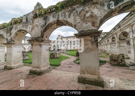 ANTIGUA, Guatemala: Le rovine del monastero e della chiesa di Santa Clara sono un silenzioso testamento della storia coloniale. La facciata ornata e le pareti sbriciolate, adagiate su uno sfondo di vegetazione lussureggiante e vulcani lontani, esemplificano l'architettura barocca e le sfide sismiche che caratterizzano il paesaggio urbano di Antigua, Patrimonio dell'Umanità dell'UNESCO. Foto Stock