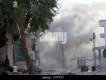 8 novembre 2012 - Aleppo, Siria: Fumo sorge da un attacco di mortaio contro un ex stazione di polizia ora controllata dal libero esercito siriano in Baba Nerab. Foto Stock