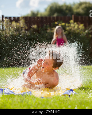 Ragazzo caucasico scorrevole in acqua Foto Stock