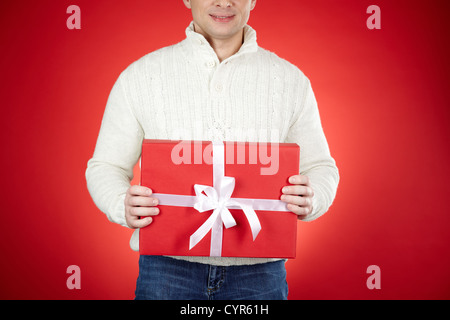 Immagine del maschio sorridente azienda red giftbox Foto Stock