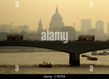 Attraversando il trasporto su Waterloo Bridge durante la London smog estivo durante l'ondata di caldo nel Regno Unito la capitale. Foto Stock