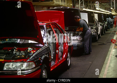 Un lavoratore auto si adatta a motori sulla linea di produzione in tedesco della BMW di proprietà di fabbrica Rover in Cowley, Solihull, Inghilterra. Foto Stock