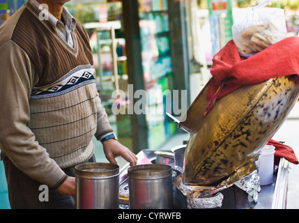 Metà vista in sezione di un uomo con il cibo in stallo in un mercato di strada, New Delhi, India Foto Stock